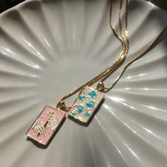 We collaborated with artist Julie Dreams to create the Tarot card necklace of our dreams. This necklaces features one kind artwork thoughtfully created by her just for us. We created this necklace in mind to pair with our Three of Cups Necklace (https://www.etsy.com/listing/1719373341/three-of-cups-tarot-pendant-necklace). Together, they make the perfect set of BFF necklaces.  Delicately detailed in enamel is our representation of the Queen of Wands card. This card is represents independence, ge Artistic Square Pendant Necklace For Gift, Artistic Enamel Necklaces As Gift, Artistic Enamel Necklaces For Gifts, Artistic Pink Necklace For Gift, Artistic Rectangular Pendant Necklace As Gift, Artistic Rectangular Pendant Necklace For Gift, Artistic Rectangular Necklace For Gifts, Artistic Rectangular Necklace For Gift, Three Of Cups Tarot