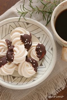 some cookies are sitting on a plate next to a cup of coffee and a napkin