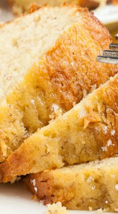 two pieces of bread on a white plate with a fork in it and another piece of bread next to it