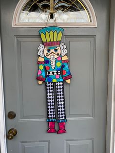 a door hanger with a cartoon figure on it's front door, in the shape of a clown