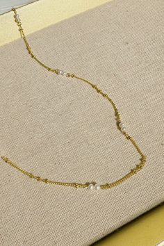 Introducing the epitome of understated elegance: a dainty bead pearl necklace that marries the timeless charm of pearls with the delicate allure of fine gold chain. Each pearl is carefully selected and spaced along the golden strand, creating a symphony of subtle sophistication that dances gracefully upon the neck. Perfect for layering or as a standalone piece, this necklace is a celebration of classic style, making it an essential addition to any jewelry collection. Graceful Gold Necklace With Pearl Charm, Delicate Gold Necklaces With Pearl Charm, Delicate Gold Pearl Chain Necklace, Graceful Gold Necklace With Pearl Chain, Gold Refined Pearl Necklace, Refined Gold Pearl Necklace, Delicate Pearl Necklace With Satellite Chain, Dainty Pearl Necklace With Beaded Chain, Delicate Gold Chain Necklace With Pearl Pendant