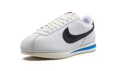 The Women’s Nike Cortez “White/Black/Light Photo Blue” is a women’s-exclusive colorway of the retro performance running shoe with a classic look.  The shoe features a white leather construction with a black leather Swoosh on both sides.  “Nike” and Swoosh logos appear on the black leather heel tab.  Additional “Nike” detailing is seen on the tongue tag.  A Light Photo Blue streak is seen in the off-white midsole.  Release date: July 14, 2023 Nike Black And White Low-top Sneakers, Nike Cortez Black And White, Nike Cortez 72, Nike Cortez White, Nike Classic Cortez Leather, Nike Classic Cortez, Blue Streaks, Black Leather Heels, Nike Cortez