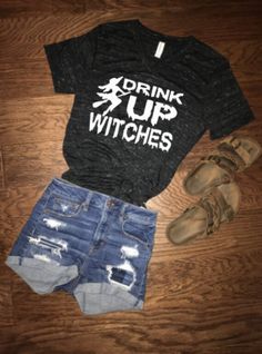 HEAD OVER TO WWW.VICTORIASMONOGRAMS.COM FOR CHEAPER PRICES Drink Up Witches! This super soft tee is perfect for trick or treating and all other Halloween   festivities!  Bella Canvas tee - black marble v-neck with white design.  S, M, L, XL, 2XL Shirt features a logo on back collar Fitted Casual Halloween Tops, Fall Graphic Tee With Distressed Details, Fitted Casual Tops For Halloween, Fall Distressed Graphic Tee, Casual Halloween T-shirt With Letter Print, Trendy Halloween Text Print T-shirt, Black Halloween Top With Text Print, Spooky Black Summer Top, Casual Halloween Letter Print T-shirt