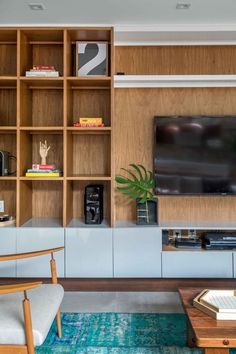 a living room filled with furniture and a flat screen tv on top of a wooden shelf