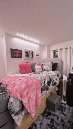 a bed room with a neatly made bed and black and white rugs on the floor