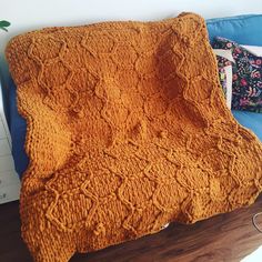 an orange blanket sitting on top of a blue couch