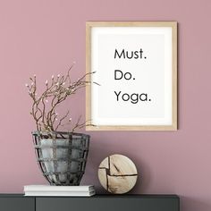 there is a vase with some flowers on top of a dresser next to a sign that says must do yoga