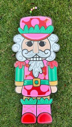 a colorful wooden figure laying in the grass