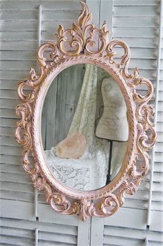 a mirror that is hanging on the side of a wall next to a dressmaker's mannequin