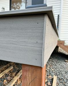 a close up of the side of a house with wood posts and siding on it