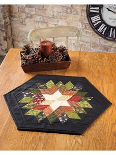 a wooden table topped with a black and white quilted placemat next to a clock