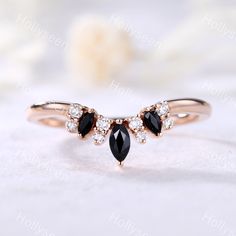 a gold ring with two black and white stones on the front, surrounded by diamonds