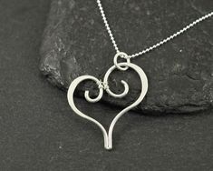 This pendant was made with sterling silver wire and and comes on a sterling silver chain. Measurements Pendant width: 27 Millimetres; Pendant height: 30 Millimetres; Necklace length: 45 Centimetres ✩ The item comes in a branded gift box- perfect for gifting.  ✩ All items are handcrafted by myself and every effort is taken to produce a high quality product.  ✩ Copper and sterling silver jewellery care: copper and sterling silver pieces will tarnish over time. To restore the shine simply polish the piece using a jewellery polishing cloth.  ✩ If you have any questions, send me a message! I am also doing jewelry upon request, so if you have an idea of what you'd like me to make for you, please get in touch to talk about it! Sterling Silver Heart Necklace Wire Wrapped, Silver Wire Wrapped Necklace For Valentine's Day, Valentine's Day Silver Wire Wrapped Necklaces, Wire Wrap Pendant, Silver Heart Earrings, Sterling Silver Heart Pendant, Music Jewelry, Love Pendant, Silver Heart Pendant