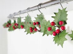 holly and red berries are hanging on the curtain rod