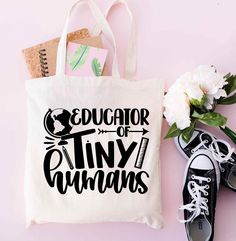 a tote bag with the words world's best teacher on it next to shoes and flowers