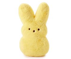 a yellow stuffed animal with black eyes on it's face, sitting in front of a white background