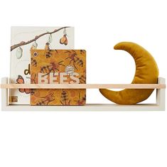 a wooden shelf with two books on it and a banana in front of the bookcase