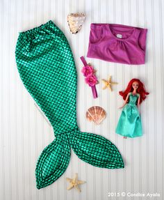 the little mermaid doll is next to her accessories