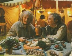 two older people sitting at a table with food in front of them and an umbrella