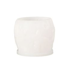 a white vase sitting on top of a table