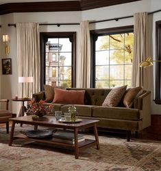 a living room with two couches and a coffee table in front of large windows