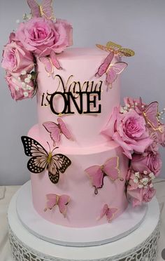 a pink cake with butterflies and flowers on it