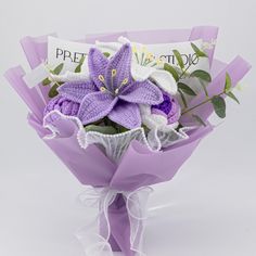 a bouquet of flowers is wrapped in purple paper