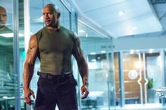 the rock is standing in front of a glass door with his hands on his hips