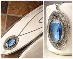 Offering an absolutely stunning vintage 1930s to 1940s era Art Deco sapphire blue bezel set faceted glass crystal, rhinestone, and silver plated filigree pendant necklace.  This is the perfect "Something Old" and "Something Blue" for the bride!   The 2 1/8 inch (5.4 cm) by just over 1 1/4 inches at 1 5/16 inches (3.3 cm) ornate embossed filigree pendant features a central oval cut bezel set faceted glass crystal in the most beautiful shade of sapphire blue.  Accenting the glass crystal are 2 pave set sapphire blue crystal rhinestones.  The pendant hangs from a silve tone replacement chain that fastens with a ring clasp and measures 24 1/4 inches (61.6 cm) around with an additional drop for the pendant.  This treasure is in excellent vintage condition with no cracks or chips to the glass cr Art Deco Pendant Necklace, Pendant Necklace Long, Filigree Pendant Necklace, Vintage Rhinestone Jewelry, 1920s Vintage, Art Deco Pendant, Filigree Pendant, Crystal Art, Necklace Long