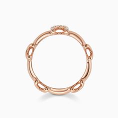 an 18k rose gold ring with diamonds on the top and bottom, set against a white background