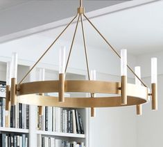 a chandelier hanging from the ceiling in front of bookshelves