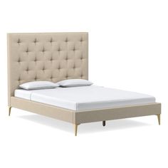 an upholstered bed with white sheets and beige headboard is shown in this image