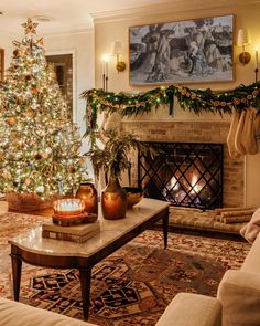 a living room with a christmas tree in the corner and decorations on the fireplace mantel