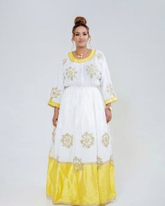 This Habesha Kemis is a true embodiment of chic and sophistication, with a beautiful Menen fabric, Shimena bottom, and Tilf dress. The Menen fabric provides a soft and luxurious texture that drapes beautifully over the body, creating an elegant and effortless fit. The Shimena bottom of the dress adds a touch of traditional Ethiopian design, with intricate patterns and vibrant colors that catch the eye. The Tilf design on the dress adds a touch of modernity and simplicity, with sleek and minimali White Zari Work Dress For Traditional Ceremonies, White Dress With Zari Work For Traditional Ceremonies, White Dress With Traditional Patterns For Eid, White Dresses With Traditional Patterns For Transitional Season, Transitional White Dresses With Traditional Patterns, White Gown With Traditional Patterns For Eid, White Traditional Drape Dress With Dabka, Traditional White Dabka Dress, White Dresses With Dabka In Traditional Drape Style