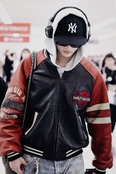 a young man wearing headphones and a jacket