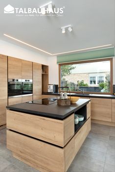 a kitchen with wooden cabinets and black counter tops in front of a large open window