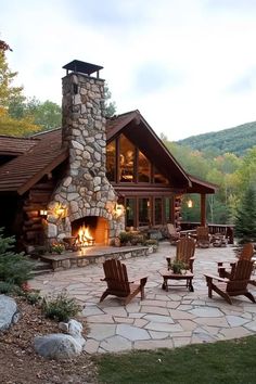 a fire place in the middle of a stone patio with chairs around it and an outdoor fireplace