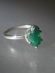 Imperfectly Perfect! This emerald came from a huge lot acquired in the late 70s. The natural inclusions in this stone along with the faceting on the back of the emerald make this ring so unique. This natural 1.56ct emerald is pear shaped cut and pavilion set (back of the stone is set face up). There is a natural clarity characteristic towards the lower tip of pear. Sterling silver mounting has five prongs and a v tip to protect the point of pear. High polished finish band tapers from 1.7 to 1.5 Green Pear-shaped Emerald Gemstone Ring, Green Pear-shaped Emerald Ring, Green Large Gemstones For Anniversary, Large Green Gemstones For Anniversary, Anniversary Large Green Gemstones, Faceted Round Emerald Ring For May Birthstone, Green Emerald Ring With Large Stone For Anniversary, Elegant Untreated Green Emerald Ring, Vintage Oval Emerald Diamond Ring