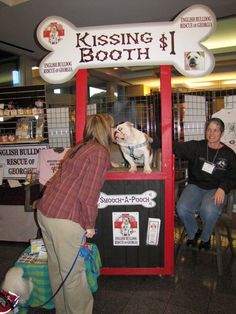 a woman is petting a dog in a booth