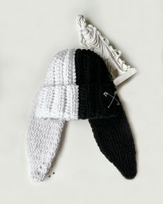 two crocheted hats laying next to each other on top of a white surface