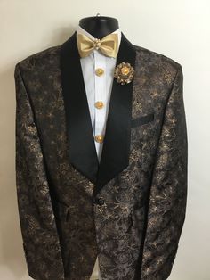 Our new chocolate and gold floral print tuxedo will be an outstanding addition to any man's wardrobe. Black satin lapels will bring a ray of elegance to your outfit. This tuxedo includes beautiful button covers, a matching carnation boutonnière, matching cufflinks, and a matching bow tie with a diamond center display.  For additional sizes, please contact the seller. Black Suits With Gold Accents Men, Luxury Gold Suit For Party, Luxury Gold Evening Blazer, Gold Festive Evening Suit, Tailored Gold Suit For Party, Gold Tailored Suits For Party, Tailored Gold Suits For Evening, Luxury Gold Blazer For Formal Occasions, Designer Gold Blazer For Formal Occasions