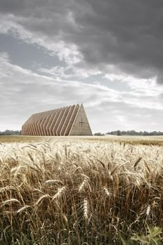 an image of a building that is in the middle of some wheat field with storm clouds above it