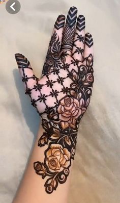 a woman's hand with henna tattoos on it