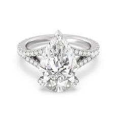 an engagement ring with a pear shaped diamond and pave set diamonds on the sides