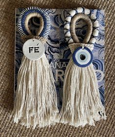 two tassels with evil eyes are hanging from a book on a carpeted surface