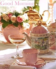 a table topped with pink dishes and cups