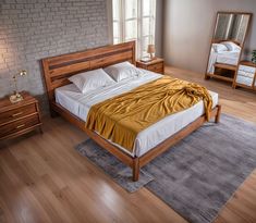 a large bed sitting on top of a hard wood floor next to a dresser and mirror