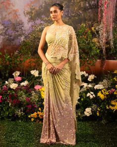 Shine brightest and sophisticatedly elegant for your after-hour soirees. Caylie saree is a meticulously crafted ensemble showcasing a perfect romance between the blush pink and serene pale green hues with dazzling sequins and nalki beads highlighting the fabric. Get ready to be that surreal beauty of the celebration. Pre-draped skirt with attached pallu adorned with nalki crystals and sequins. Draped structured blouse with net highlighted with small floral embroidery with the use of sequins and beads. The blouse and saree both have a back zipper with a hook. From Moledro’s Firdaus collection. DELIVERY TIMEPlease allow 8-12 weeks for your outfit to arrive. FABRIC DETAILSBlouse : Butterfly Net and GeorgetteSaree : GeorgettePallu : Butterfly Net Professional cleaning only. Structured Blouse, Surreal Beauty, Butterfly Net, Draped Skirt, Green Hues, 12 Weeks, Professional Cleaning, Pale Green, Blouse Styles