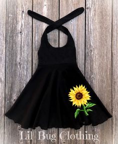 The Perfect Sunflower Girl Dress This cute custom boutique handmade sunflower dress would be perfect for spring, summer, and fall. This dress is a nice soft black knit, halter style with an adorable sunflower applique on front of dress. This sunflower dress would be perfect to wear on a special occasion, great for photos, a birthday gift or just a fun day for your baby girl out in the sun. Your little girl will love twirling around in this cute little yellow sunflower dress. Perfect For Pictures Sunflower Theme Birthday Party, Sunflower Theme Birthday, Yellow Sunflower Dress, Jojo Wedding, Elmo Dress, Sunflower Applique, Sunflower Outfit, Bug Clothing, Sunflower Girl