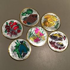 four plates with different designs on them sitting on a counter top next to each other